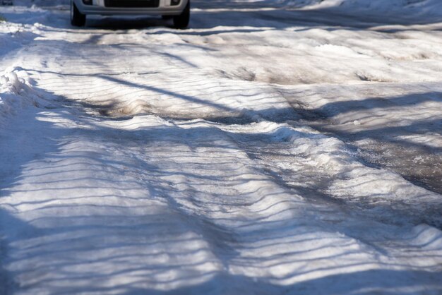 Frozen road with many potholes Terrible road in countryside during winter season