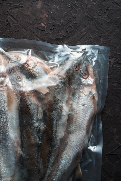 Frozen smelt in vacuum packing on a beige background