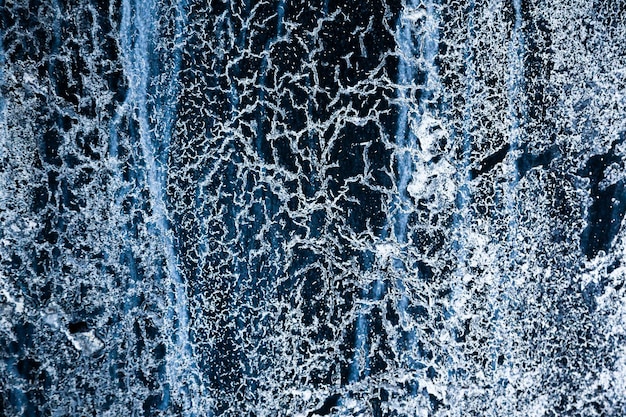 Frozen water with various ice patterns cracks and drips