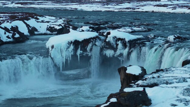 A frozen waterfall in iceland with ice on the bottom