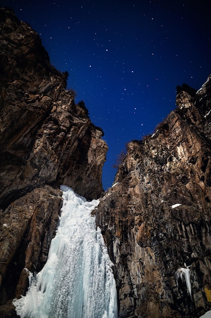 Frozen waterfall at night starry sky