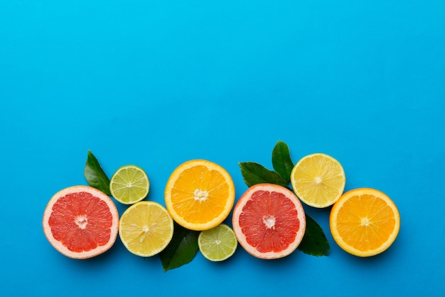 Fruit background Colorful fresh fruits on colored table Orange lemon grapefruit Space for text healthy concept Flat lay top view copy space