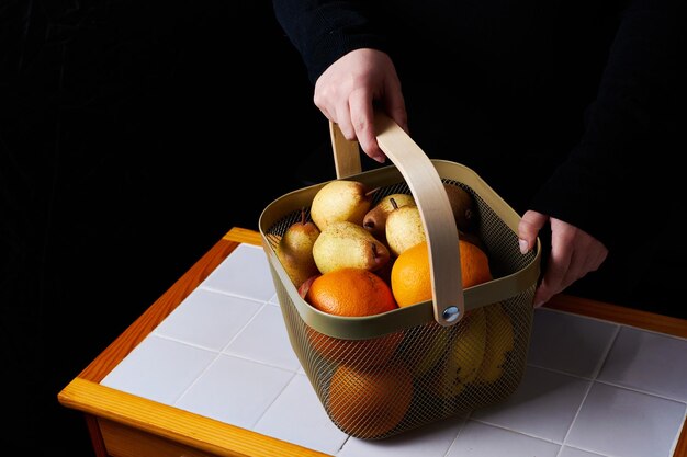 Fruit basket on table held in hands