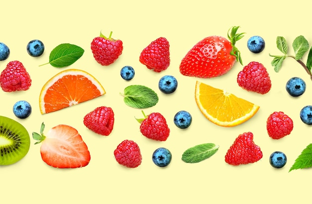 Fruit and berry pattern of various ripe berries and leaves on yellow background. Fruit border frame banner. Flat lay.