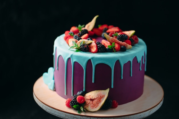 Fruit cake decorated with figs, blueberries, raspberries and mint.