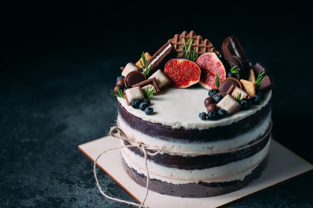 Fruit cake decorated with figs, cookies and blueberries.