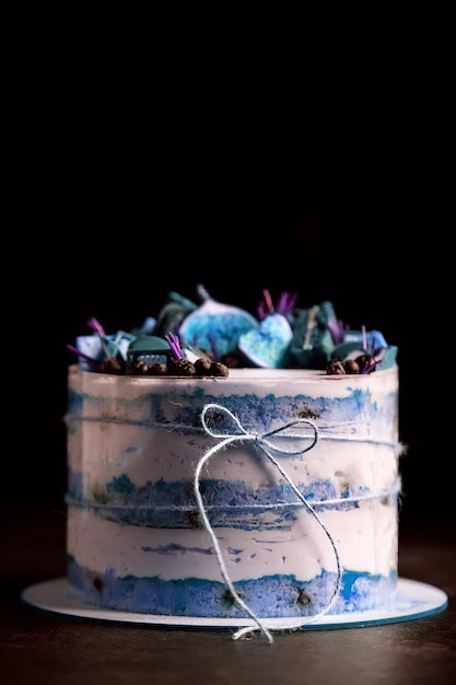 Fruit cake decorated with figs, cookies and blueberries.