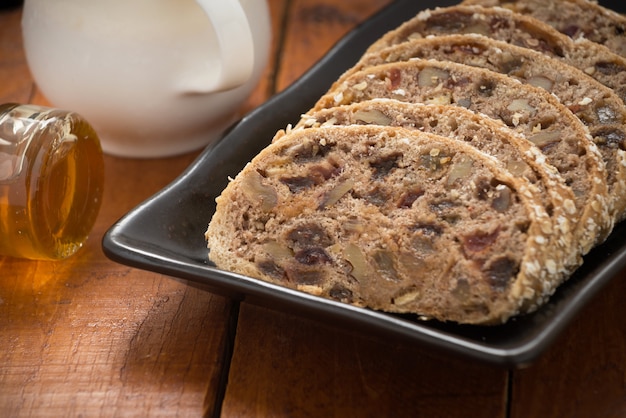 Fruit Loaf or bread with raisins also known as Bara Brith and milk or orang juice on wood