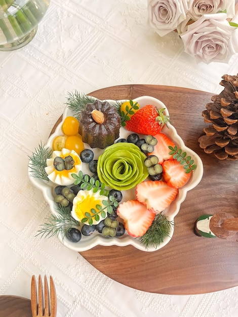 A fruit platter with a white plate with a white rose on it.