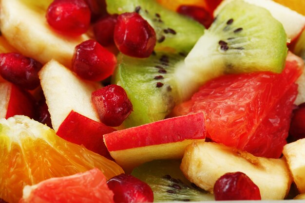 Fruit salad close-up in full screen, as a background. Slices of fresh and healthy fruits for a healthy diet.