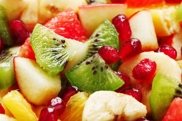 Fruit salad close-up in full screen, as a background. Slices of fresh and healthy fruits