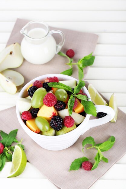 Fruit salad in cup on wooden table