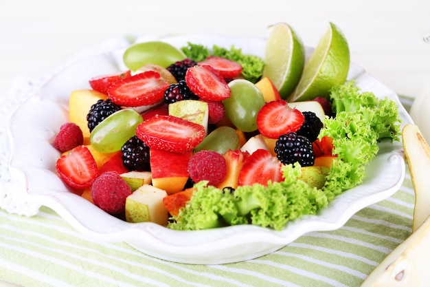 Fruit salad in plate on napkin wooden table