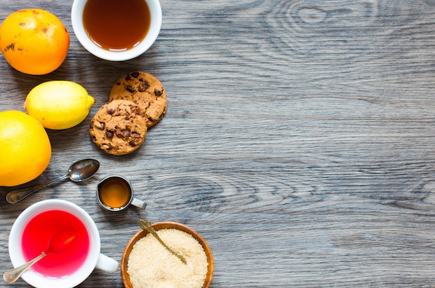 Fruit tea with lemon, milk, honey, orange, pomegranate, on a wooden background