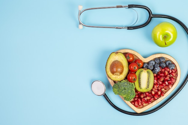 Fruit and Vegetable; Blueberries, cherry Tomatoes, Avocado, Broccoli, Kiwi and green apple on blue background. weight loss, nutrition, Healthy food, Dieting and vegetarian concept