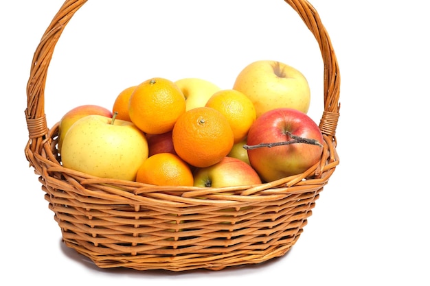 Fruits, apples and tangerines in a wicker basket on white background.