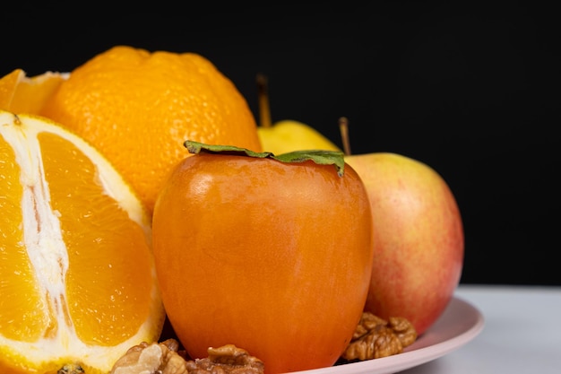 Fruits of orange and yellow colors apples persimmons and oranges