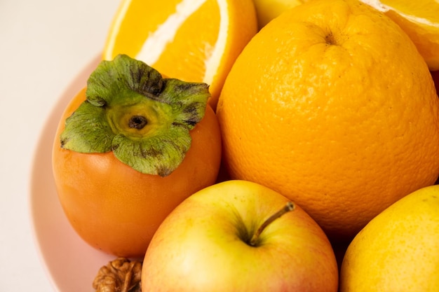 Fruits of orange and yellow colors apples persimmons and oranges