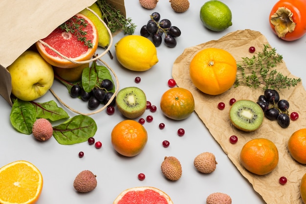 Fruits in paper bag. Persimmon, kiwi and orange on table