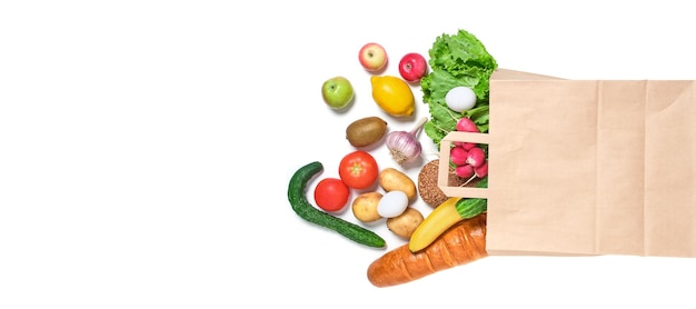 Fruits vegetables and products in a paper grocery bag on a white background