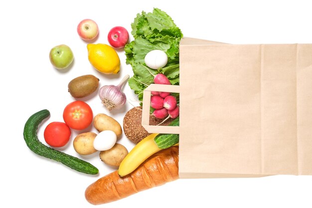 Fruits vegetables and products in a paper grocery bag on a white background