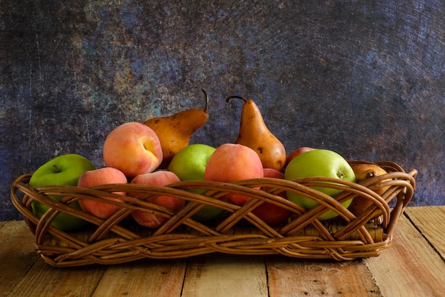 Fruits in wicker basket on wooden table