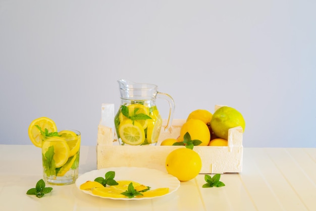 Fruitscut pieces of lemon mint leaves lemon drink in a jug flowers healthy drink with mint  lemon