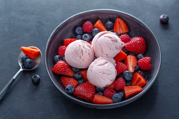 Fruity strawberry Ice cream scoops served on plate with fruits. Closeup