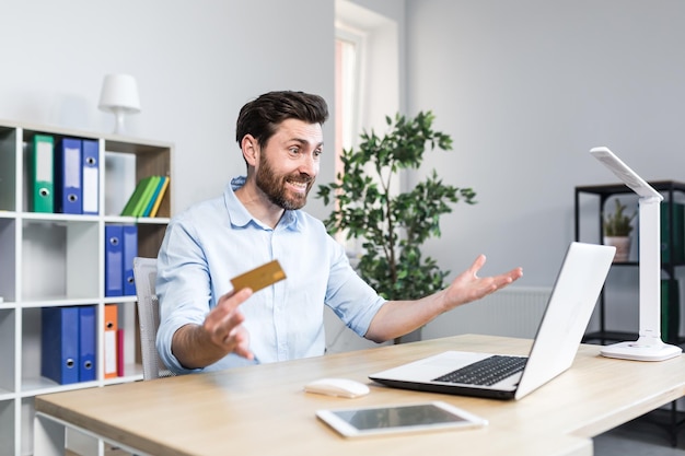 Frustrated and angry man in the office trying to make a purchase in an online store a businessman with a bank credit card angry got a banking error