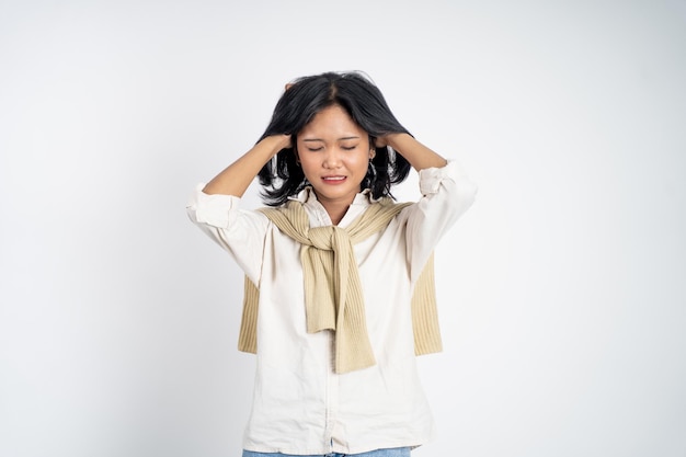 Frustrated asian young woman holding head with headache