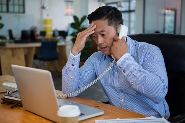 Frustrated business executive talking on telephone