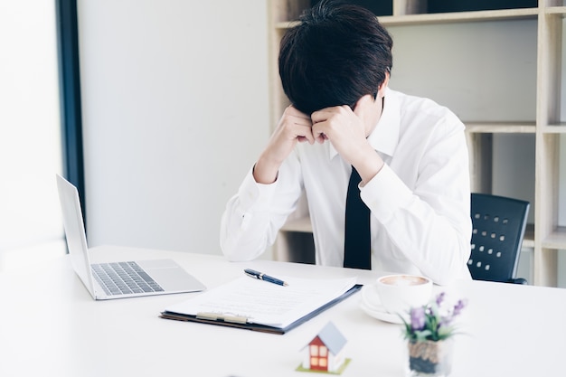 Frustrated business man stress when fail with real estate agent work while sitting at desk