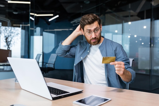 Frustrated and deceived businessman in office trying to make purchase in online store and online