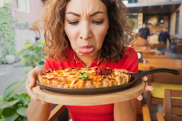 A frustrated woman in a restaurant does not feel the smell and taste of food because of the long covid effect or because of a bad cook