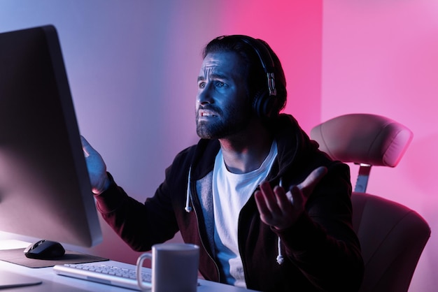 Frustrated young man looking at the computer monitor and gesturing