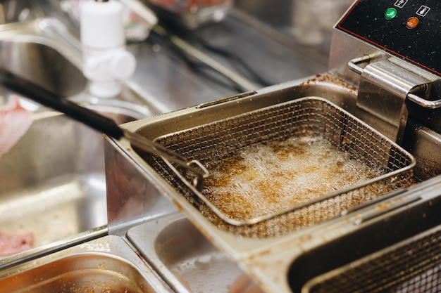 Frying chicken nuggets in deep fryer Restaurant meal preparation