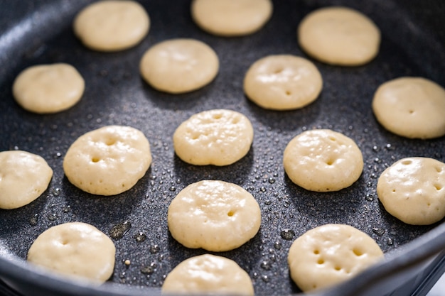 Frying mini pancake cereal in a nonstick frying pan.