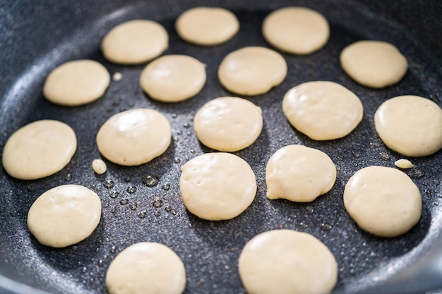 Frying mini pancake cereal in a nonstick frying pan.