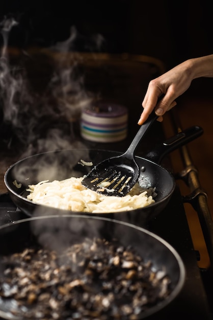 Frying mushrooms in a pan Finely chopped champignons are cooked Steam is coming