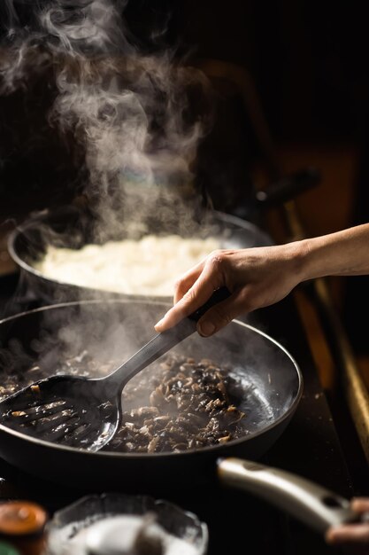 Frying mushrooms in a pan Finely chopped champignons are cooked Steam is coming