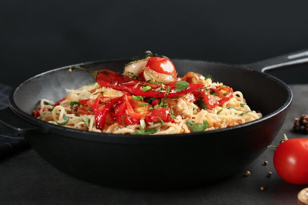 Frying pan with delicious chicken spaghetti on table