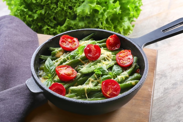 Frying pan with delicious green bean casserole on kitchen table