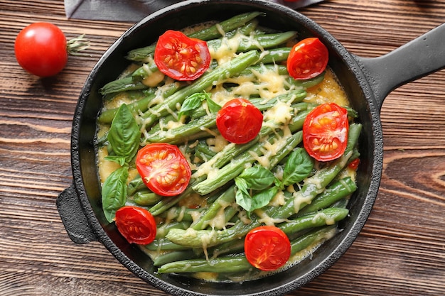 Frying pan with delicious green bean casserole on wooden table