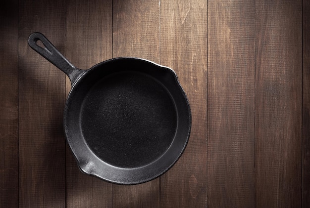 Frying pan  on wooden background texture