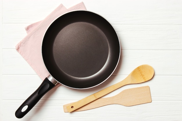 Frying pan and on the wooden table top view cooking