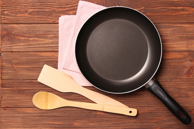 Frying pan and on the wooden table top view cooking