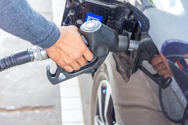 Fuel nozzle add fuel in car at gas station