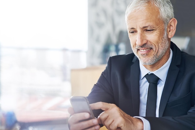 Fuelling innovation with technology Cropped shot of a mature businessman texting on a cellphone in an office