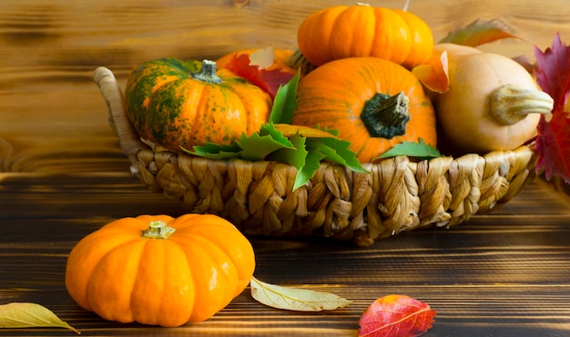 Full basket with pumpkins on wooden background