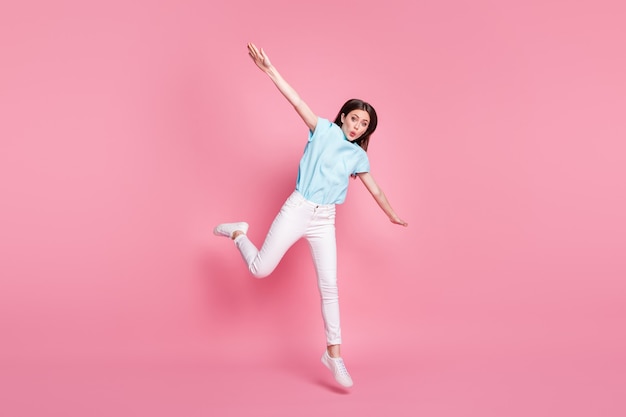 Full body photo of astonished girl jump hold hands wear white gumshoes isolated over pink color background